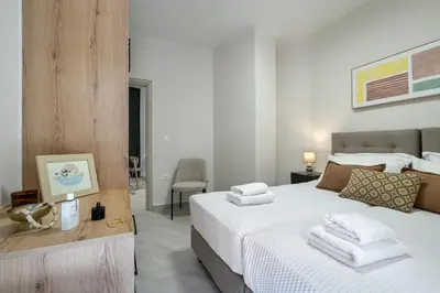 a bedroom with a white bed with towels on it at Coralie 3 bedroom apartment 40m from the beach in Chania Town