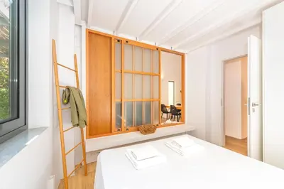 a white room with a bed and a window at Central cozy garden flat in Chania Town