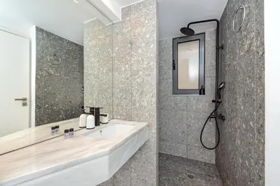 a bathroom with a sink and a shower at Central cozy garden flat in Chania Town