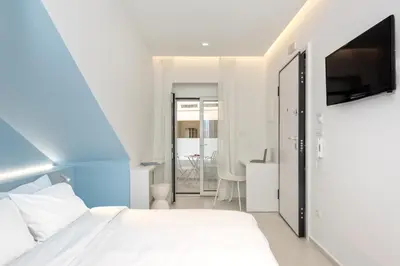 a bedroom with a white bed and a tv at Αthena Studio 3 in Chania Town