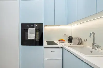 a kitchen with white cabinets and a black refrigerator at Αthena Studio 3 in Chania Town