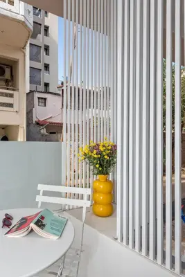 a white table and a yellow vase with flowers on a balcony at Αthena Studio 3 in Chania Town