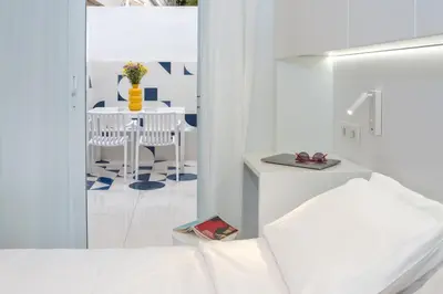 a white room with a table and a white bed at Athena Studio 1 in Chania Town