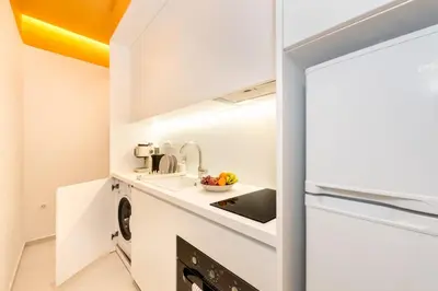 a white kitchen with a sink and a dishwasher at Athena Studio 1 in Chania Town