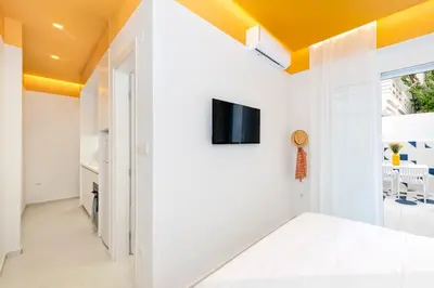 a living room with white walls and a yellow ceiling at Athena Studio 1 in Chania Town