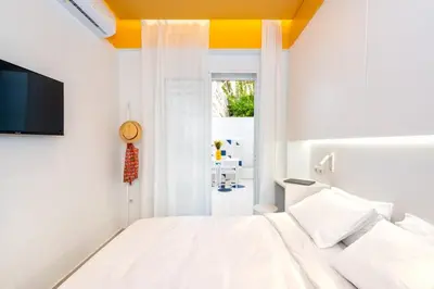 a bedroom with a white bed and a tv at Athena Studio 1 in Chania Town
