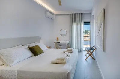 a white bedroom with a large bed with towels on it at Terra Chic Retreat Suite in Chania Town