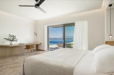 a bedroom with a bed and a desk with a view at Only View Villa - Timeless Coastal Retreat by etouri in Chania