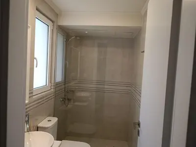 a bathroom with a shower and a toilet and a sink at Apartment Odysea in Plataniás
