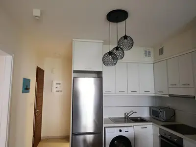a kitchen with a stainless steel refrigerator and white cabinets at Apartment Odysea in Plataniás