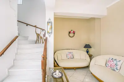 a living room with two chairs and a staircase at Creta Sea View 2BR Maisonette by ΜΡS in Marathokefála
