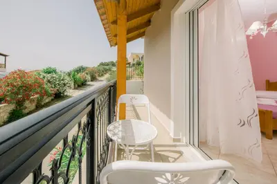 a balcony with two chairs and a table at Creta Sea View 2BR Maisonette by ΜΡS in Marathokefála