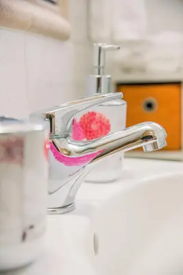 a bathroom sink with a faucet with a red sponge at Creta Sea View 2BR Maisonette by ΜΡS in Marathokefála