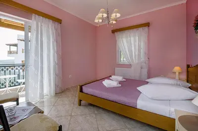 a bedroom with a bed with pink walls and a balcony at Creta Sea View 2BR Maisonette by ΜΡS in Marathokefála