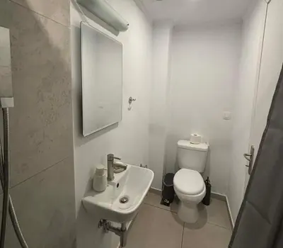 a white bathroom with a toilet and a sink at Athina's Cozy Guest House in Kamisianá