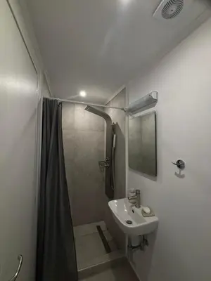 a bathroom with a shower and a sink at Athina's Cozy Guest House in Kamisianá