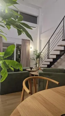 a living room with a green couch and stairs at Hanim 2BR Loft Apartment - Garden & Indoor Parking in Chania Town