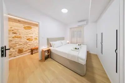 a white bedroom with a bed and a hallway at Hanim 2BR Loft Apartment - Garden & Indoor Parking in Chania Town