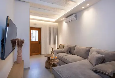 a living room with a couch and a tv at Bōw Ground Floor Luxury Apt-In Chania Old Town! in Chania Town