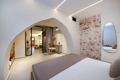 a bedroom with a white bed and an archway at Bōw Ground Floor Luxury Apt-In Chania Old Town! in Chania Town
