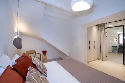 a bedroom with a bed and a staircase at BŌW 1st Floor Luxury Apt -Heart of Chania Old Town in Chania Town