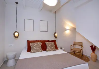 a bedroom with a large bed and a chair at BŌW 1st Floor Luxury Apt -Heart of Chania Old Town in Chania Town