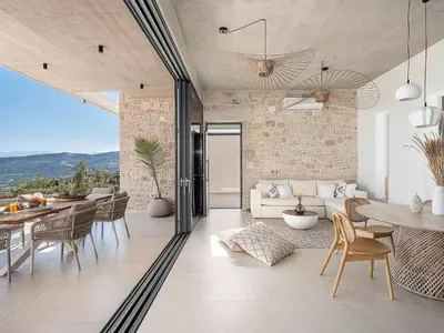 a living room with a table and chairs and a couch at Himmel Villas - Seaview luxury & private pools in Kalivianí