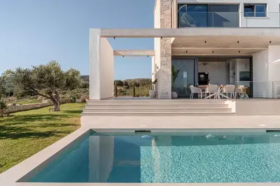 a house with a swimming pool in front of a house at Himmel Villas - Seaview luxury & private pools in Kalivianí