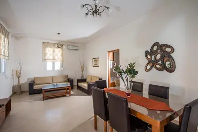 a living room with a table and a dining room at Lila Villas in Stalos