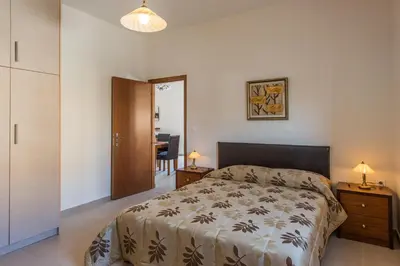 a bedroom with a bed and a table with a chair at Lila Villas in Stalos