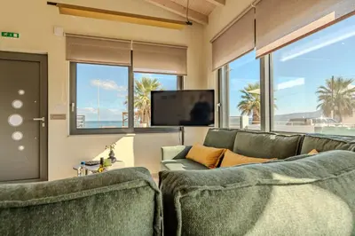 a living room with two couches and a flat screen tv at Seawhisper Villa in Kalyves