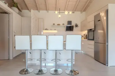 a kitchen with a table with stools and a refrigerator at Seawhisper Villa in Kalyves