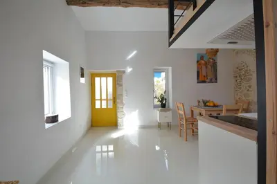 a living room with a yellow door and a dining room at Agapi in Kissamos