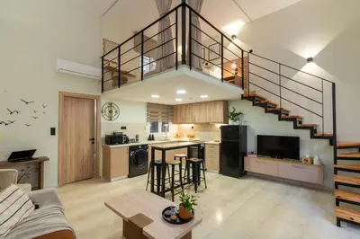 a large kitchen and living room with a staircase at La Petite Fleur City apartment Chania in Chania Town