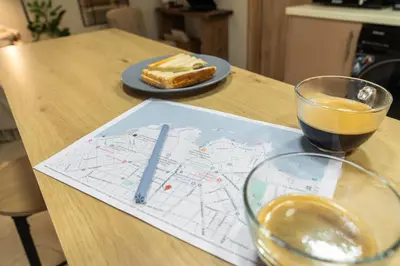 a table with a map and a glass of orange juice at La Petite Fleur City apartment Chania in Chania Town