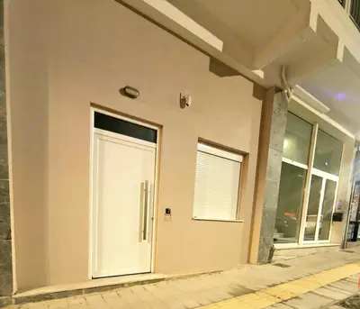 a white door on the side of a building at La Petite Fleur City apartment Chania in Chania Town