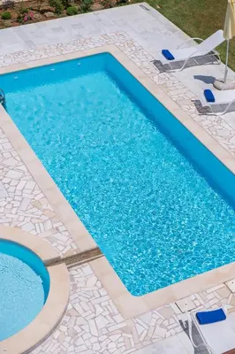 a swimming pool with blue water in a yard at Koukos Villas in Stalos