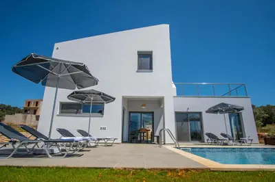 a house with a pool and chairs and umbrellas at Villa Alen in Áptera