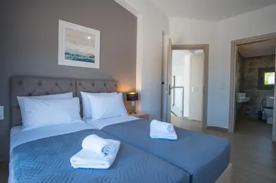 a bedroom with a blue bed with towels on it at Villa Alen in Áptera