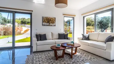 a living room with two couches and a table at Villa Alen in Áptera