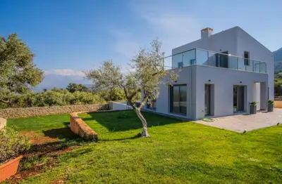 a white house with a tree in the yard at Villa Alen in Áptera
