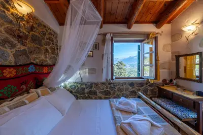 a bedroom with a large bed and a window at Maria's Serene Countryside Retreat in Chania Town