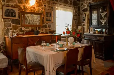 a dining room with a table with a white table cloth at Maria's Serene Countryside Retreat in Chania Town