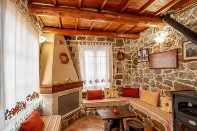 a living room with a stone wall at Maria's Serene Countryside Retreat in Chania Town