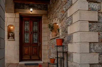 a front door of a stone building with vases on it at Maria's Serene Countryside Retreat in Chania Town