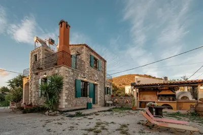 an old stone house with a chimney and a patio at Maria's Serene Countryside Retreat in Chania Town