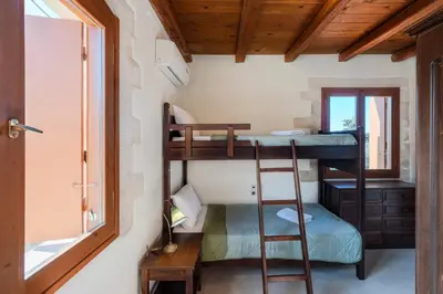a room with two bunk beds and a window at Vamos villa in Vamos