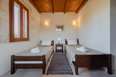two twin beds in a room with a window at Vamos villa in Vamos
