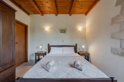 a bedroom with a large bed with two night stands at Vamos villa in Vamos