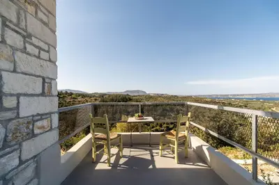 a balcony with a table and chairs on it at Villa Falcos by PosarelliVillas in Gavalochori